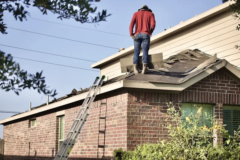 Professional roofer working on a residential roof in Riegelsville